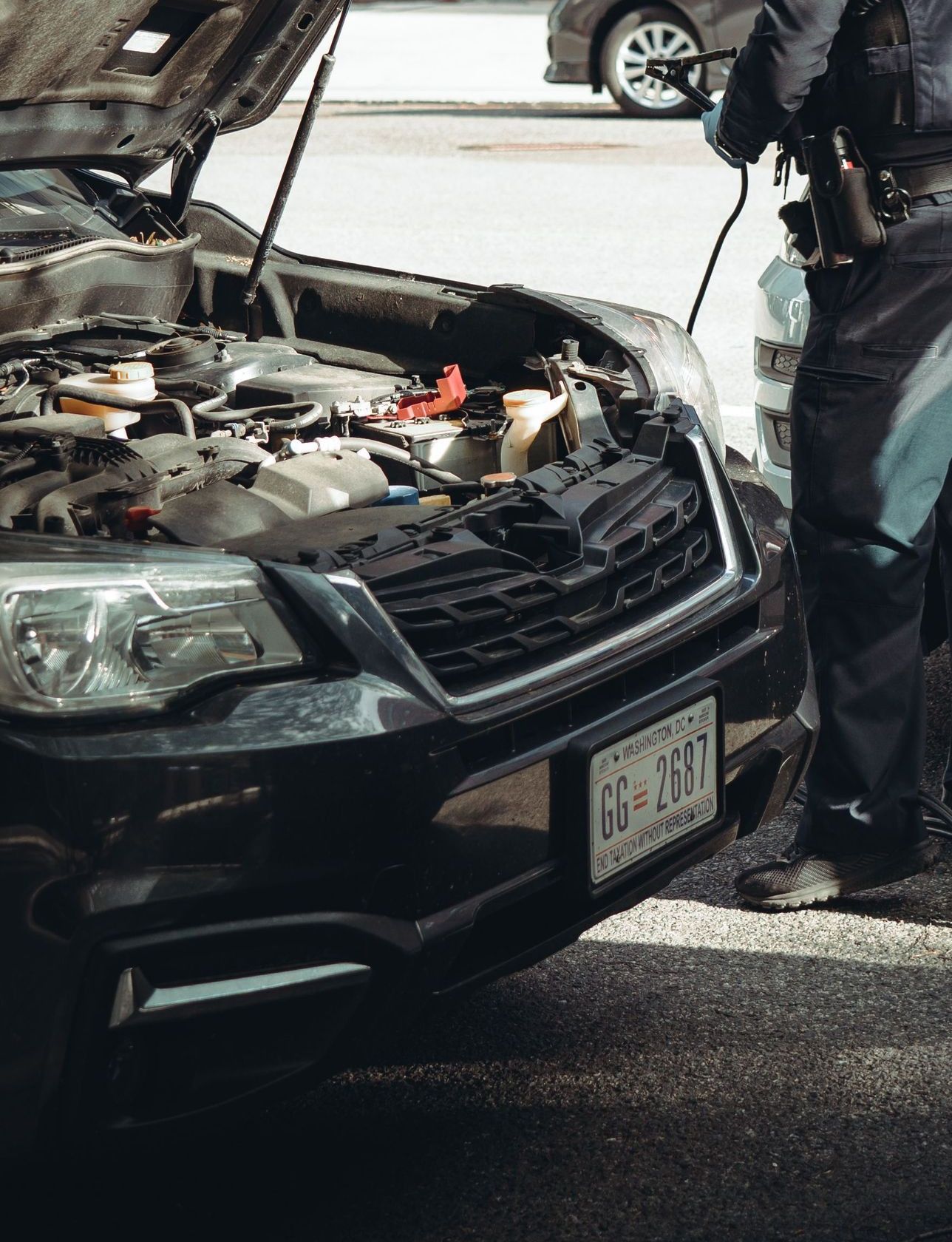 A police officer assists a car with a breakdown on the streets of Washington DC.